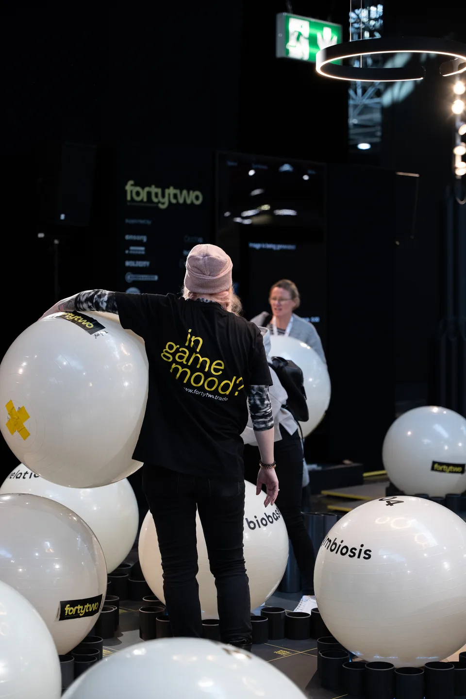 Forty Two Trade, event and structure: visitor carrying a white ball at the stand, print “in game mood” on the sweater