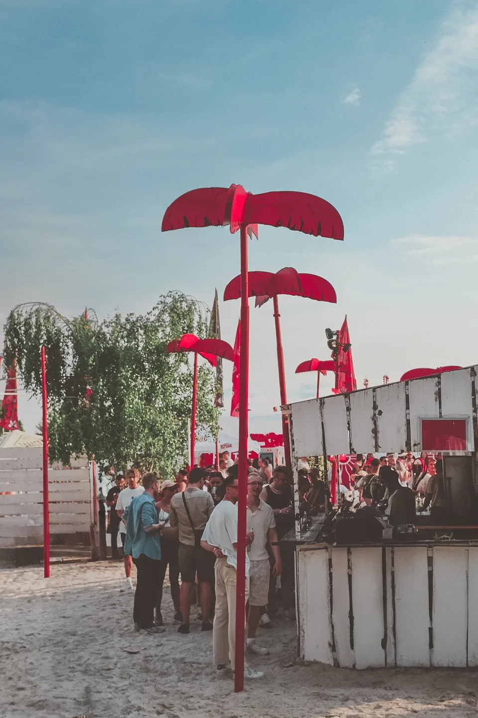 Kiesgrube Open Air, Event und Struktur: rote Schirmstruktur über einer Bar mit Besucher:innen