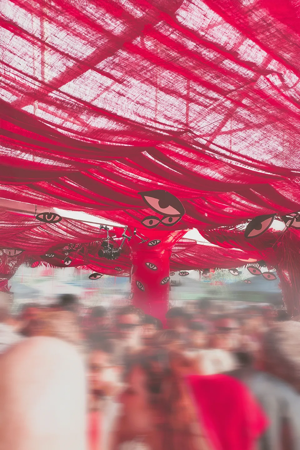 Kiesgrube Open Air, Event und Struktur: rotes Stoffdach mit aufgedruckten Augen über einer feiernden Menge
