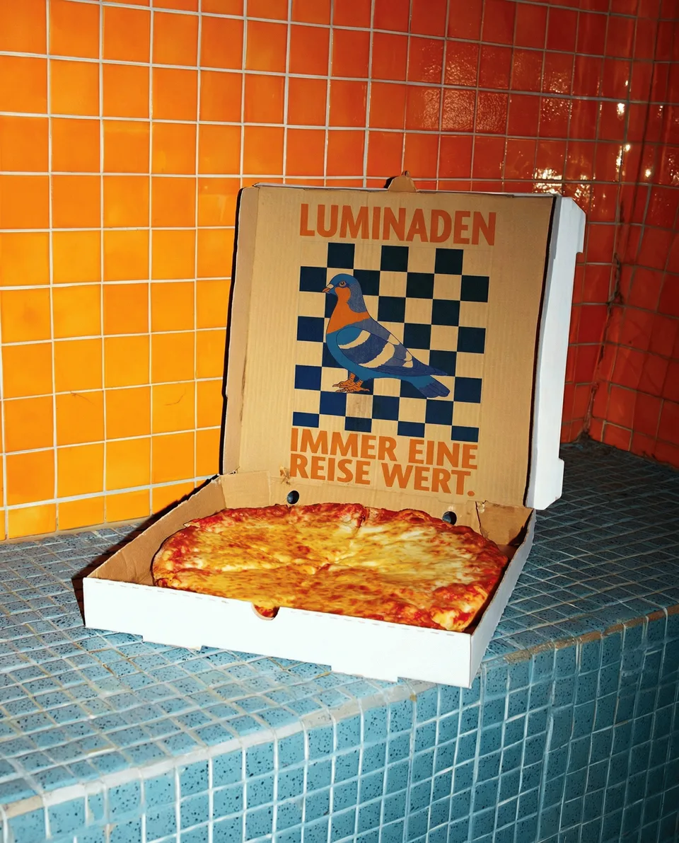 Luminaden, brand space: pizza box in the Luminaden design on an orange tiled counter