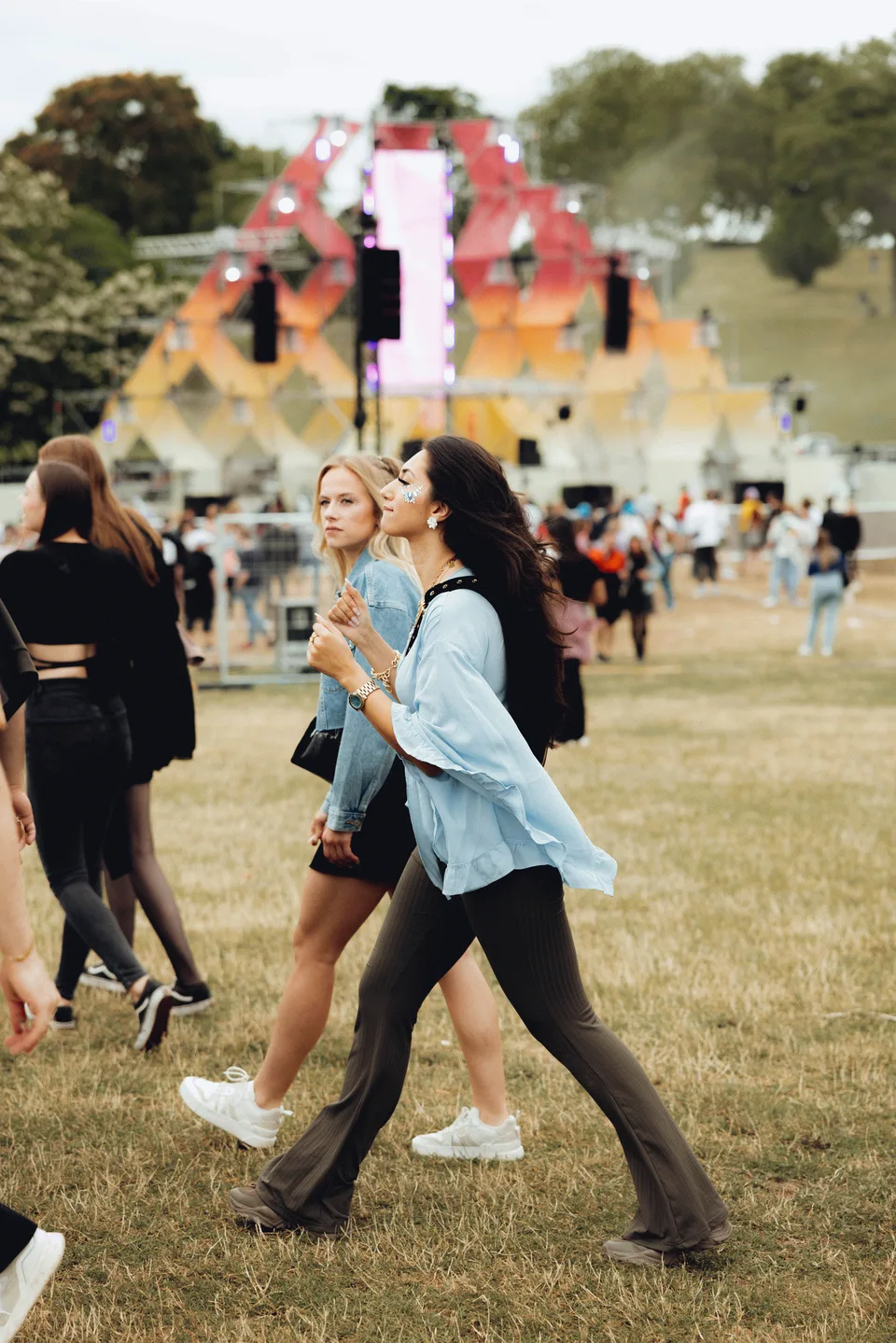 Panama Open Air, Event und Struktur: zwei Frauen gehen über die Festivalwiese, im Hintergrund die Bühne