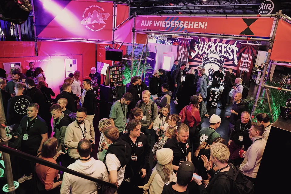 Stageventure & Friends, Event und Struktur: Menschenmenge am Stand unter dem Schild „Auf Wiedersehen“ in rotem und violettem Licht